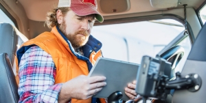 Truck driver looking down at digital tablet